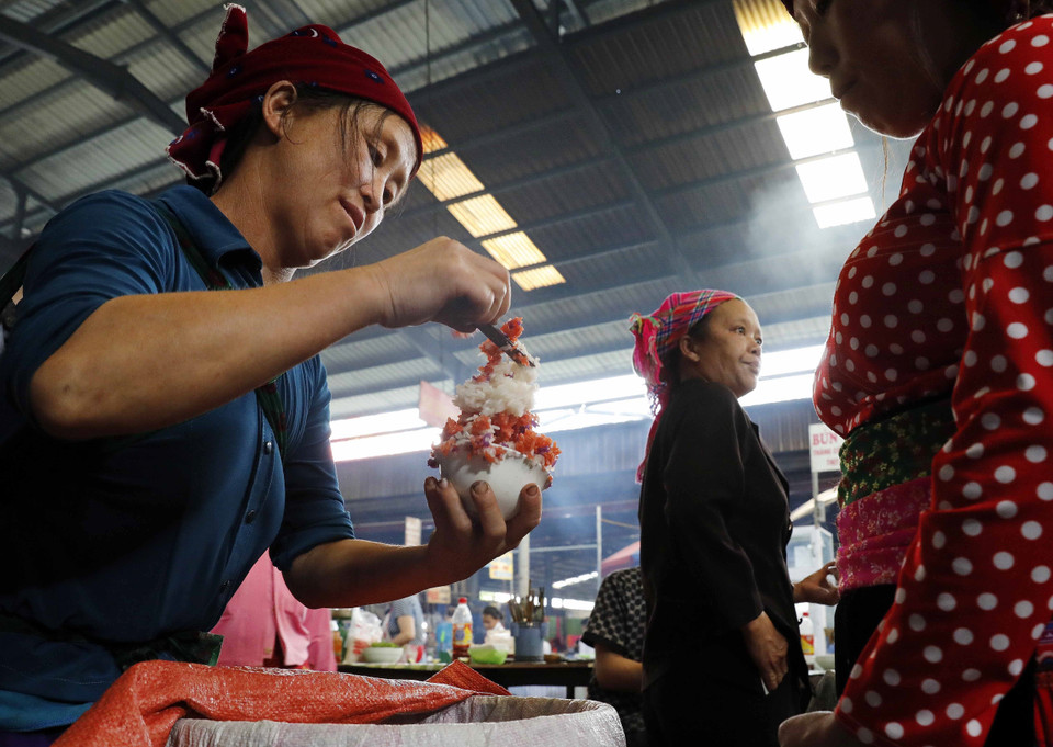 Le xôi ngu sac ou le riz gluant aux cinq couleurs de l'ethnie Tay est vendu au marché. Photo: VNA