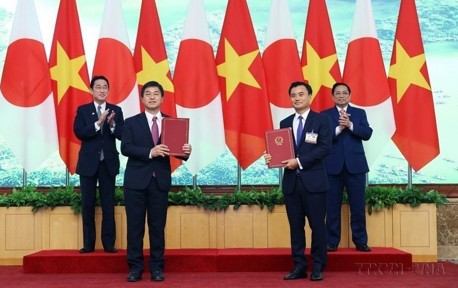 Le Premier ministre Pham Minh Chinh (droite, arrière-plan) et son homologue japonais Kishida Fumio (gauche, arrière-plan)) à la cérémonie d'échange de ''l'annexe au contrat n° 19 du contrat général de consultation dans le cadre du projet de construction de la ligne de métro N°1 de Ho Chi Minh-Ville", le 1er mai 2022 à Hanoï. Photo : VNA