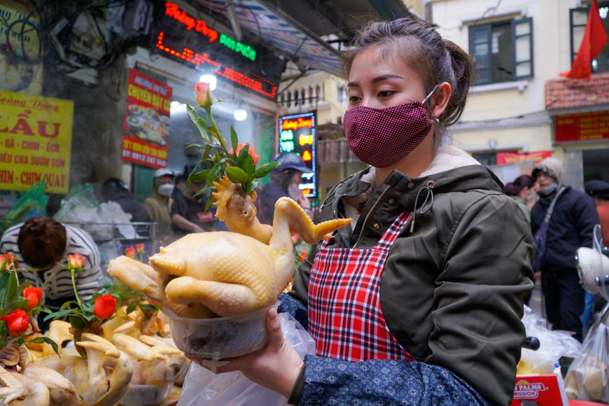 La cuisson est elle aussi déterminante. Le coq est placé dans une grande marmite d’eau chauffée à environ 70-80°C. Une fois le coq cuit, on le sort de la marmite puis on le trempe dans de l’eau froide tout en retouchant la pose. Afin de rendre sa peau plus dorée, on l’enduit d’une couche de graisse de poulet mélangée avec du safran. Il ne reste qu’un dernier maillon: la présentation. On dépose le coq dans une assiette de xôi et on ajoute une rose dans le bec. Chaque coq de culte vendu au marché Hang Be, pèse de 1,5kg-2kg et son prix oscille entre 500.000 et 600.000 dongs. Photo: Vietnamplus