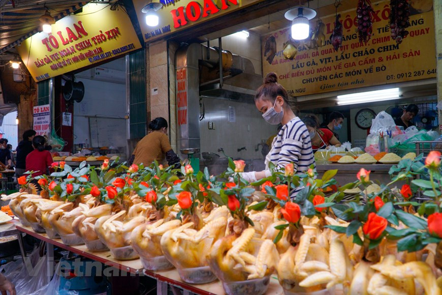 L’un des spécialités du marché Hang Be est le coq de culte. En effet, parmi les offrandes de culte préparées lors des fêtes (familiales ou communautaires), outre un plateau de xôi (riz gluant cuit à vapeur), le poulet bouilli à l’eau est un élément le plus important. Il est agréable de voir sur le plateau rituel un joli coq doré et de belle prestance. Cet «oiseau sacré» peut se présenter dans des positions différentes, appelées par exemple «Coq en vol» (gà bay), «Coq en prosternation» (gà quy), «Coq en audience royale» (gà châu), «Coq aux ailes de fée» (gà canh tiên)… Il existe même un art de la cuisine dédié exclusivement à la préparation et à la présentation du coq de culte. Photo: Vietnamplus