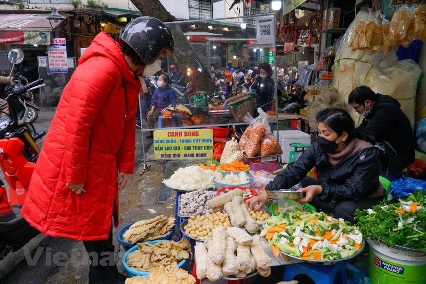 Au marché Hang Be, on vend également des plats prêts à manger, dont "canh bong". Le nom de ce plat fait référence à la technique et aux astuces de sa cuisson. On commence par faire tremper séparément dans l’eau tiède, pendant environ 15 à 20 minutes, la couenne de porc, les champignons parfumés, les crevettes sèches. La peau du porc devient plus souple. Elle est ensuite nettoyée avec un peu d’alcool et quelques morceaux de gingembre. La couenne est découpée en morceaux rectangulaires et assaisonnée de sel, de poivre, de saumure de poisson. La carotte est découpée en petites rondelles assez fines. Le chou-rave et le brocoli sont coupés en morceaux. Photo: Vietnamplus