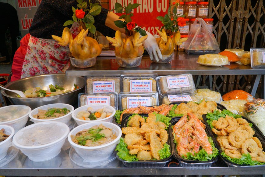 Outre le coq de culte, on peut acheter d’autres plats tels que xoi gac (riz gluant mélangé avec la pulpe de momordique et cuit à vapeur), le "nem" (rouleaux de printemps frits), canh mang (soupe aux cuisses de porc et aux pousses de bambou mijotées), bo sot tieu den (bœuf sauté en sauce au poivre noir), nom du du (salade de papaye verte), gio (pâté de viande pilée), giò thu (pâté de tête de porc) …Le Têt Nguyên Tiêu permet de se retrouver en famille. Plus les plateaux sont riches, plus cela exprime le respect envers les ancêtres. Les plateaux traditionnels se composent de nombreux mets et symbolisent tous divers souhaits et vœux de chaque famille pour la nouvelle année. Photo: Vietnamplus