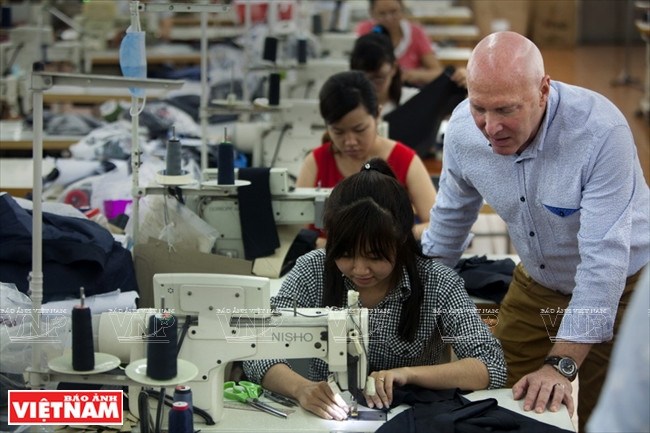 Michael Laskau instruit les travailleurs sur le processus de production pour assurer la qualité des produits.