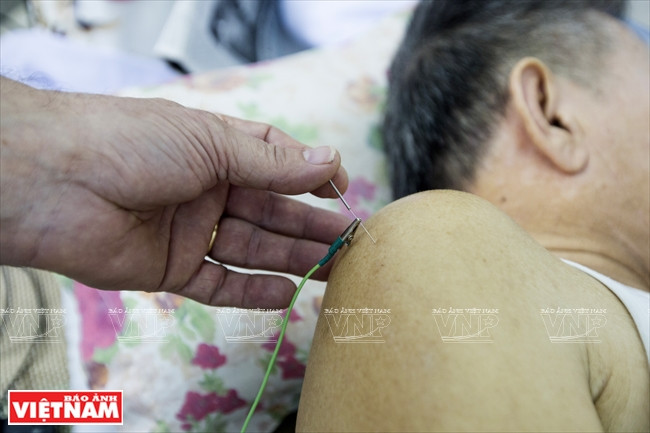 Marc Mézard pratique l’acupuncture sur un malade à l’Institut de la médecine et de la pharmacie traditionnelles de Ho Chi Minh-Ville.