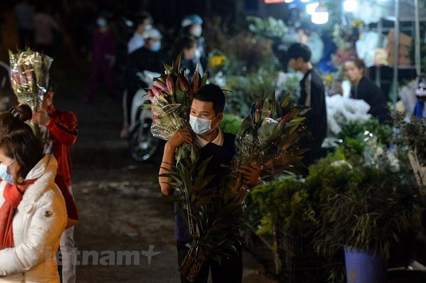 Le marché nocturne aux fleurs de Quang An n’est pas seulement un endroit où on vend en détail et en gros des fleurs, mais il attire également des gens venus contempler les fleurs et prendre des photos souvenir. On y trouve tous les types de fleurs. Et on rencontre parfois des amoureux qui offrent de belles fleurs à leurs amoureuses. Il est inondé des couleurs et saveurs avec tout type de fleurs. Contempler des centaines de sortes de fleurs chatoyantes et rencontrer les vendeurs avec leur conseil sur place, vous serez entièrement comblé par cette balade nocturne à Hanoi. Cette année, en raison de l’offre limitée, le rix de fleurs augmente par rapport aux années précédentes. Photo : VietnamPlus
