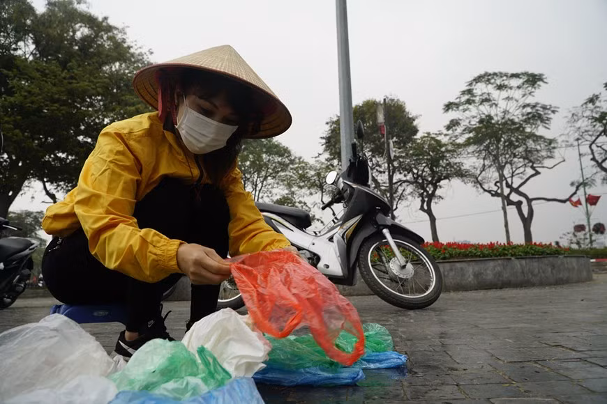 Nguyên Vu Ngoc Bich, employée du Centre Thiên Tâm An, recueille des sacs plastiques au lac de l'Ouest, un lieu où les gens libèrent les carpes. Elle a dit faire ce travail depuis 7 ans. L'habitude de consommation de plastique est ancrée depuis longtemps dans la vie quotidienne des Vietnamiens. Que cela soit dans les marchés traditionnels, supermarchés, restaurants ou cafés, les emballages en matières plastiques sont monnaie courante. Une grande commodité pour les vendeurs et les clients, ainsi qu'un prix bon marché expliquent cette popularité. En effet, il suffit de dépenser 10.000 à 20.000 dôngs pour un lot de 50 gobelets de 25-30 cl, ou encore 5.000 à 10.000 dôngs pour 100 pailles à usage unique. Un kilogramme de sacs en nylon ne coûte qu’entre 30.000 et 50.000 dôngs. Photo : VietnamPlus 