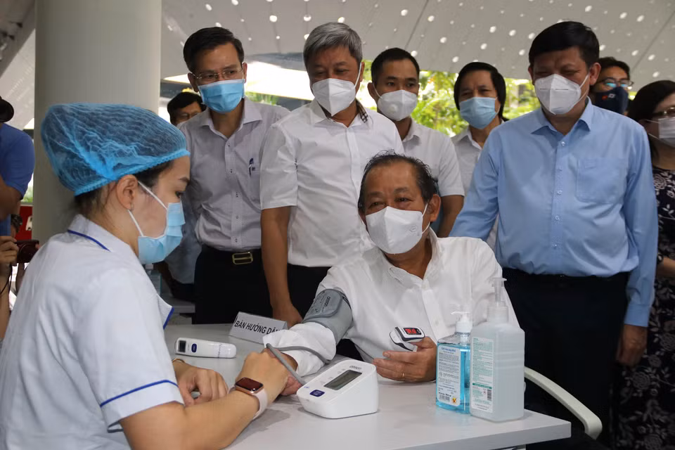 Une professionnelle de santé mesure la tension artérielle du vice-Premier ministre permanent Truong Hoa Binh après le lancement de la campagne de vaccination contre le Covid-19 à Hô Chi Minh-Ville. Photo : VNA