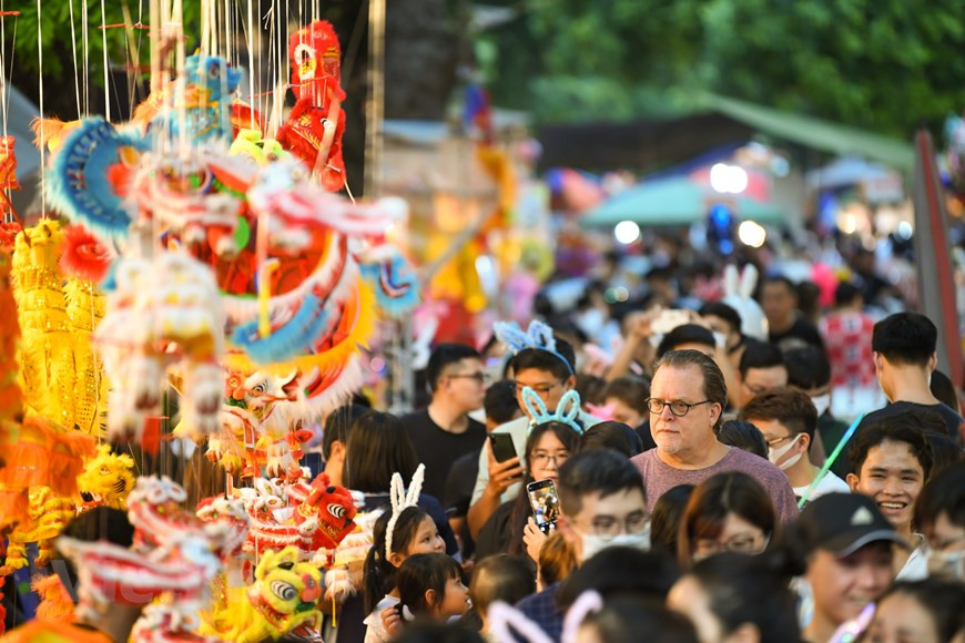 Au Vietnam, dans un “mâm cỗ Trung thu" traditionnel se déploient les couleurs des fruits emblématiques des cinq éléments que sont le métal, le bois, l’eau, le feu et la terre. Les fruits peuvent varier selon les régions mais se composent le plus souvent de bananes, pamplemousses, mangues et de dragons. S’y ajoutent les incontournables gâteaux de lune : le "bánh nướng" (gâteau farci cuit au four) et "bénh dẻo" (gâteau gluant de pâte de riz sucrée). Personne ne sait exactement l'origine de cette tradition d’offrir ces saveurs typiques à ses proches et amis. Toujours joliment décorés, ces gâteaux à base de farines, de graine de haricot, de lotus, de thé vert, de poulet rôti… sont mis dans les boîte de couleurs symbolisant la fête vietnamienne typique, jaune et rouge. Photo: VietnamPlus 