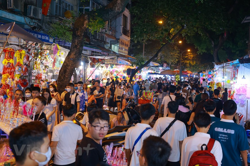 Le lieu privilégié de la Fête de la Mi-automne est normalement une cour ou une terrasse spacieuse. La soirée venue, tout le monde apporte une attention particulière à la préparation d’un plateau d’offrandes de fruits, le “mâm cỗ Trung thu". C’est aussi l’occasion de mettre en relief l’imagination des femmes et des filles dans la décoration des fruits. Lorsque la lune est la plus lumineuse, c’est l’heure de”Phá cỗ”, littéralement “attaquer les friandises”. Petit ou âgé, on s’amuse bien avec tant de sourires et de jeux folkloriques. Plus tard, les membres de la famille s’assoient ensemble pour déguster des gâteries tout en appréciant la beauté de la lune. Photo: VietnamPlus 