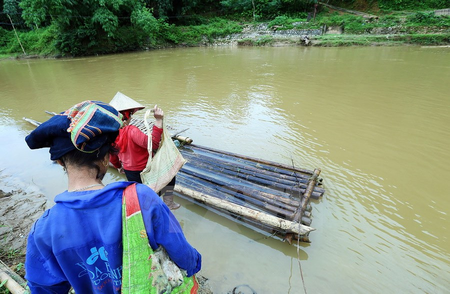 Il y a plus de trois ans, les autorités locales ont dû démonter un ancien pont suspendu sur la rivière Nâm Hua, obligeant les minoritaires ethniques locaux à emprunter des radeaux de bambou rudimentaires pour traverser la rivière. Photo: VNA