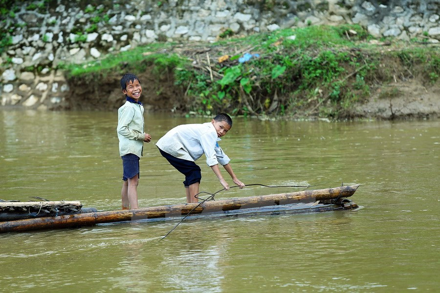 Une trentaine de foyers vivant dans le hameau de Pom Sinh, commune de Chiêng Dông, district de Tuân Giao, province montagneuse de Diên Biên (Nord-Ouest), doivent risquer leur vie pour traverser la rivière en radeau de bambou. Photo: VNA