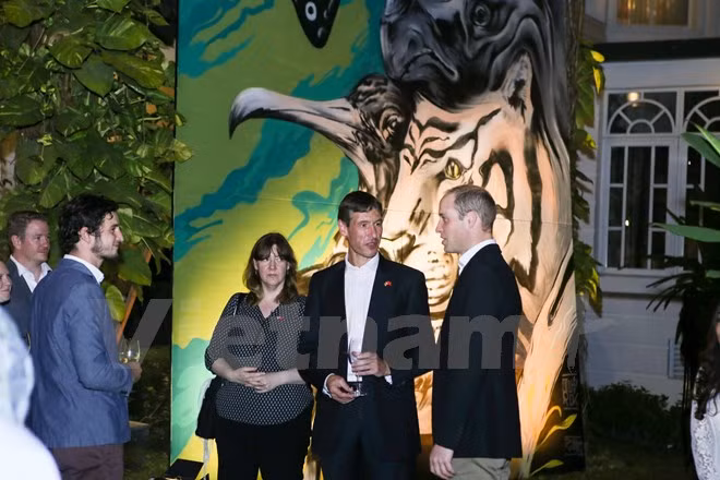 Le Prince William à côté d'une peinture d’animaux de Tran Tien Dung et de Samuel Murdorch (Britannique).