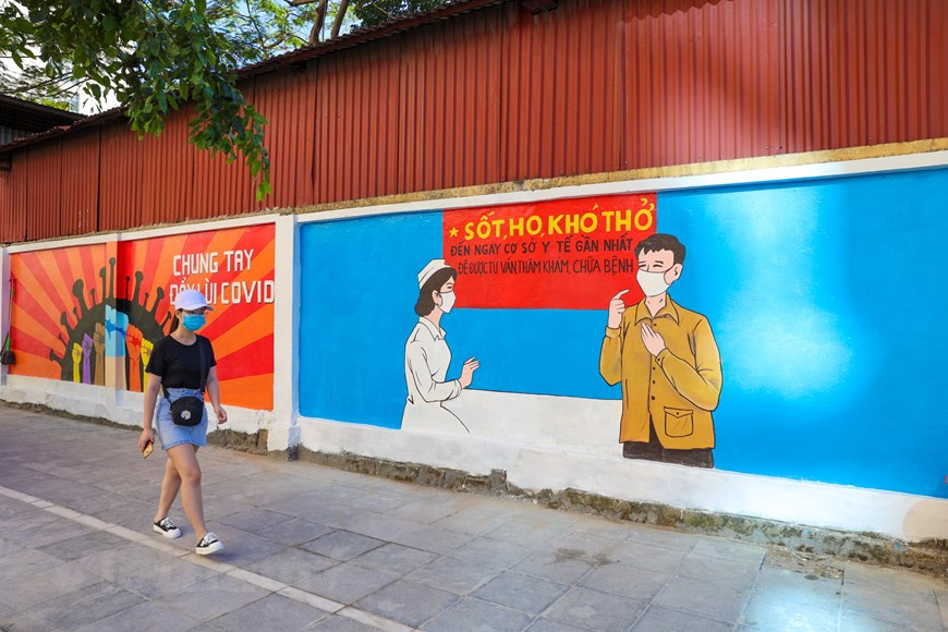 Les belles paroles de ces dix peintures murales constituent non seulement une gratitude envers les forces engagées dans la lutte contre l’épidémie de Covid-19, mais encore des louanges à l'esprit d'unité nationale - un esprit très «vietnamien» -, comme "la volonté du Vietnam peut a un pouvoir magique", "toute la nation est unie quand la Patrie et l’Etat appellent son nom", "il y a des grands sacrifices silencieux contre le combat du Covid-19 sans balles", "notre pays est petit, mais très fiers des deux mots "Viêt Nam"", "un esprit vietnamien, une solidarité fait la force»… Tout pense que le Vietnam devra vaincre cette épidémie. Photo : VietnamPlus