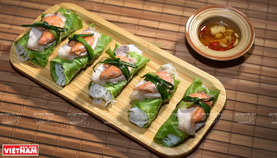 Rouleaux de laitue au riz gluant fermenté, crevettes et viande : un bon plat apprécié des Hanoïens en été. Photo: VNP Au moment de déguster ce plat, étalez la laitue verte fraîche sur une assiette, mettez un petit morceau de vermicelle de riz blanc, un morceau de viande du ventre du porc émincé finement, une crevette, puis plongez-y une petite cuillère de riz gluant fermenté. Roulez la feuille pour former un rouleau, puis tremper-le dans une sauce aigre-douce. -VNA