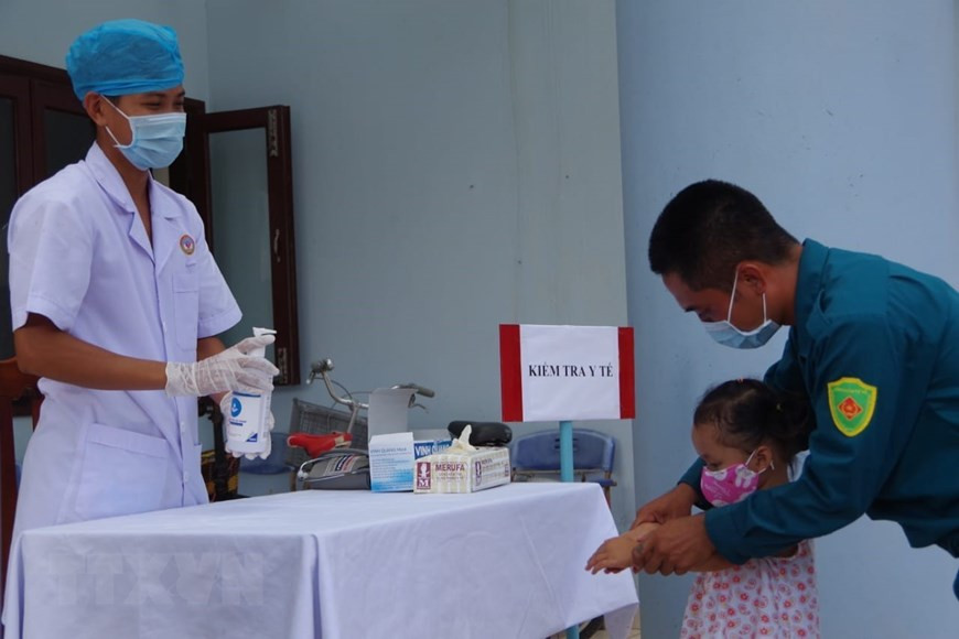 Un médecin militaire du centre médical du bourg de Truong Sa indique à un parent des mesures préventives. Photo: VNA
