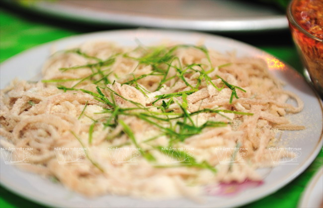 Le plat est servi avec des tranches de porc bouilli, couenne de porc mélangés avec de la poudre de riz torréfié.