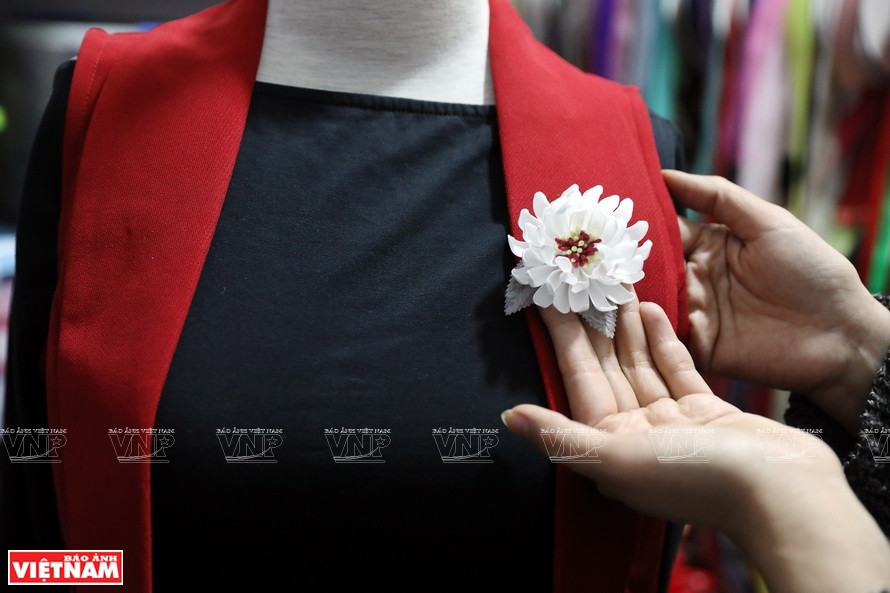 Ngô Thi Thom revoit un produit sur une chemise avant de le donner à sa cliente. Photo: Vietnam Illustré