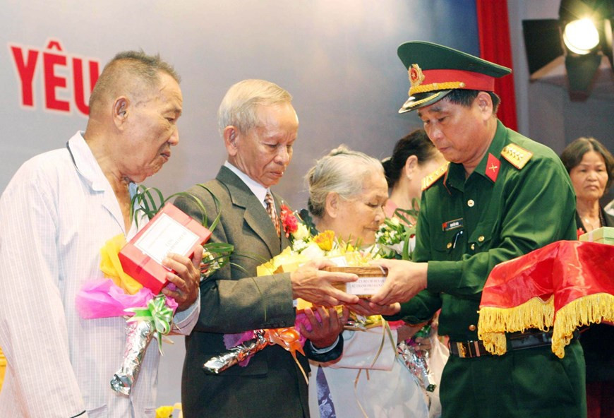 Le colonel Nguyen Min, chef adjoint du commandement militaire de la ville de Da Nang (Centre), remet des cadeaux aux familles des soldats morts dans la bataille de Gac Ma en 1988, lors d'un événement tenu le 14 mars 2013. Photo : VNA