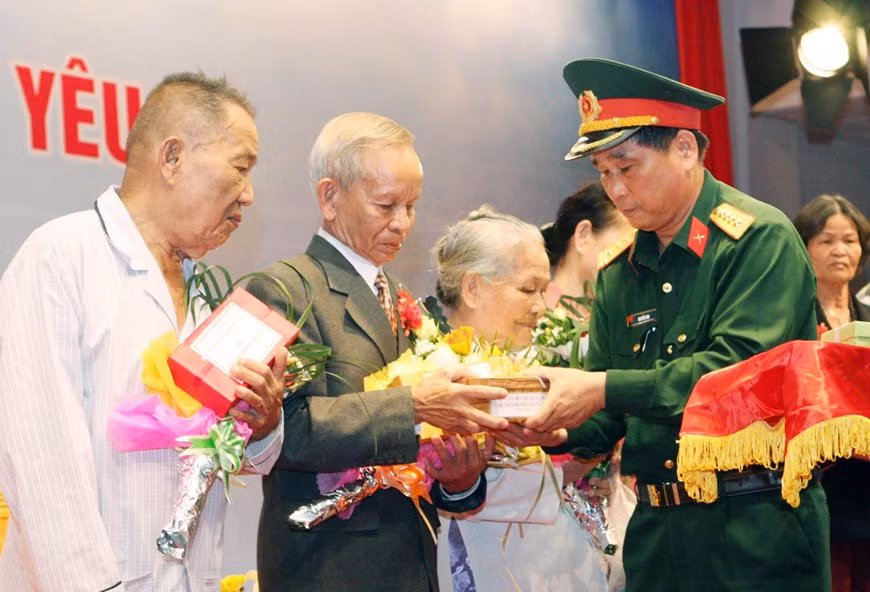 Le colonel Nguyen Min, chef adjoint du commandement militaire de la ville de Da Nang (Centre), remet des cadeaux aux familles des soldats morts dans la bataille de Gac Ma en 1988, lors d'un événement tenu le 14 mars 2013. Photo : VNA