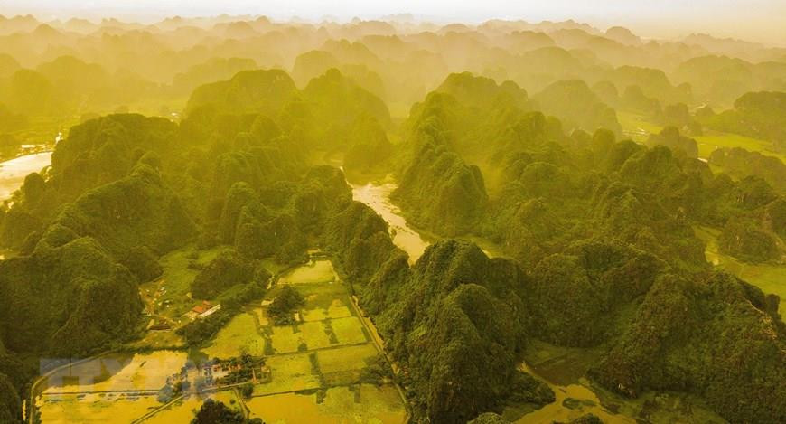 L'aube à Tam Coc-Bich Dong en automne couvre les montagnes de jaune.