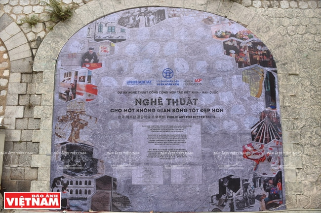 Une pile du viaduc de la rue Phùng Hung couverte de peintures murales.