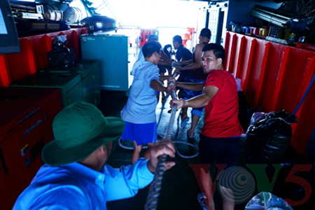 Enthousiastes, les soldats attrapent les sacs tout en accueillant les membres de la délégation.