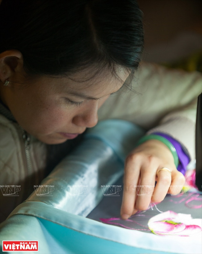 Un artisan exécute à l’aiguille une broderie célèbre XQ.