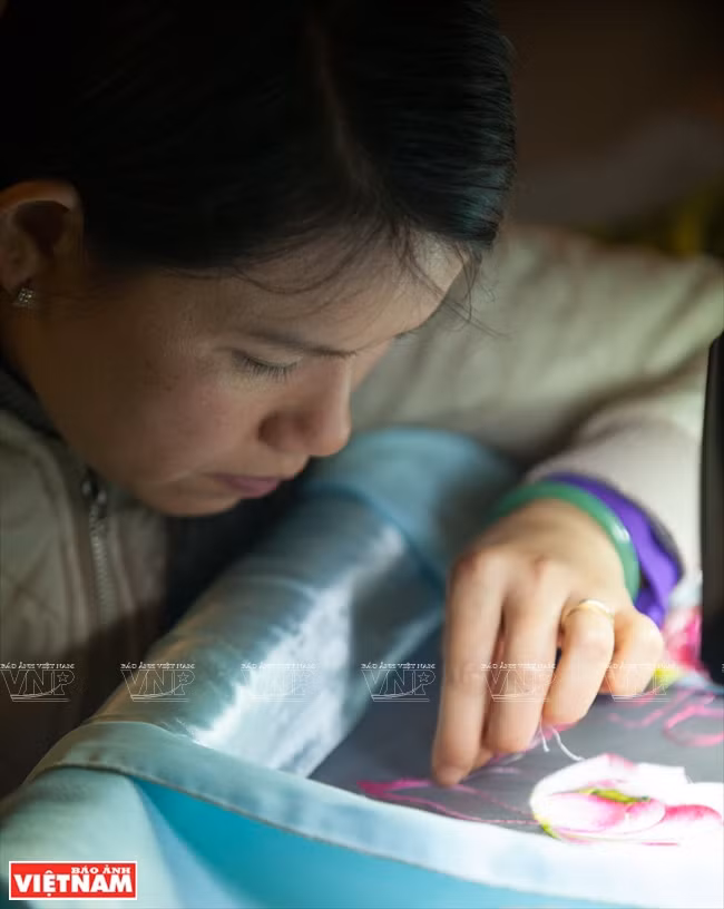 Un artisan exécute à l’aiguille une broderie célèbre XQ.