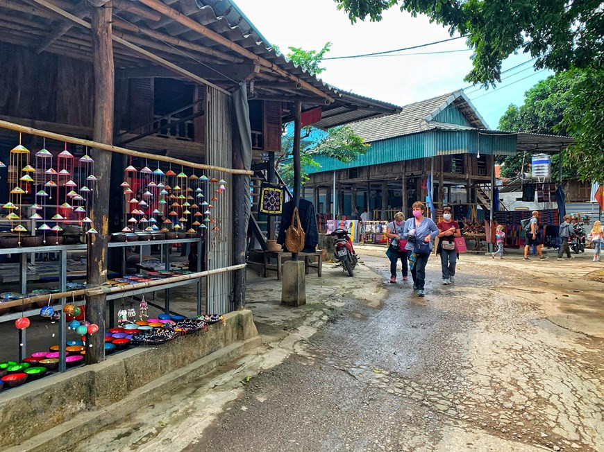 Le village de Lac, district de Mai Chau, dans la province montagneuse du nord de Hoa Binh, est une destination à ne pas manquer pour les touristes et les amateurs de plein air et d'aventure, en particulier les visiteurs internationaux, car il est considéré comme une escapade sûre et belle dans la région nord-ouest du Vietnam. Des touristes étrangers, notamment des touristes européens, considèrent Mai Châu comme une escapade sûre lors de leur voyage au Vietnam. Des visiteurs portent des masques de protection en faisant le voyage dans le village de Lac. Les petits chemins les emmènent aux différentes maisons sur pilotis traditionnelles. Photo: Vietnam+