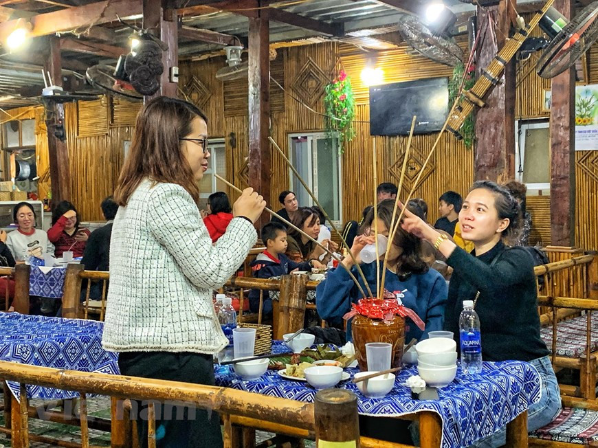 De nombreux touristes ont déclaré qu'ils suivaient de près chaque jour l'évolution du COVID-19 au Vietnam et ont décidé de faire un voyage de printemps, car le Vietnam a bien contrôlé la maladie. En particulier, en visitant le village de Lac, les touristes ne peuvent pas manquer les spécialités locales. Les touristes seront invités à s'asseoir sur le tapis orné au centre de la maison. Ensuite, ils seront invités à déguster du ruou cân (une sorte de vin populaire dans les hautes terres et bu dans un bocal à travers des tuyaux), du com lam (une sorte de riz délicieux) avec de la viande grillée et du poisson d'eau douce cuit à la vapeur. Photo: Vietnam+