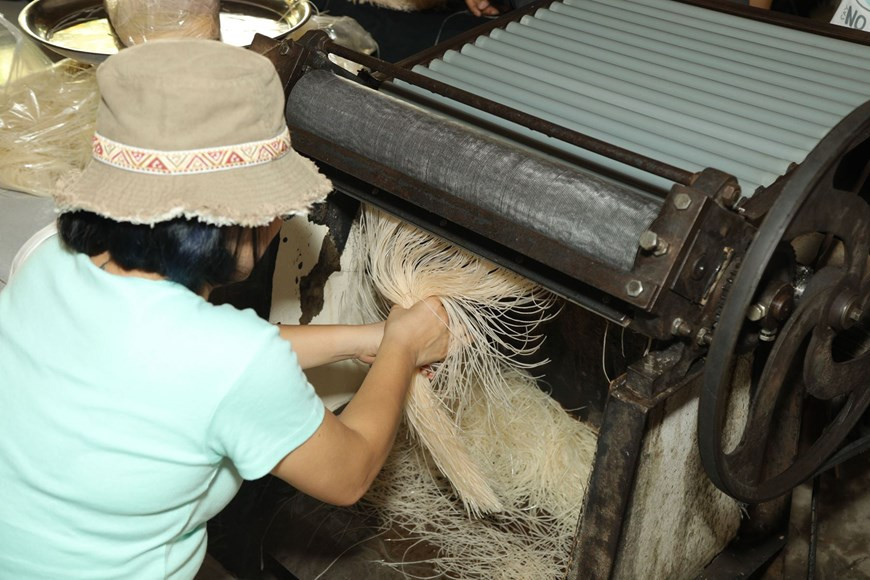 Après le séchage sous le soleil, les papiers sont mis dans une machine à rouler les nouilles. Photo: Vietnam+ 