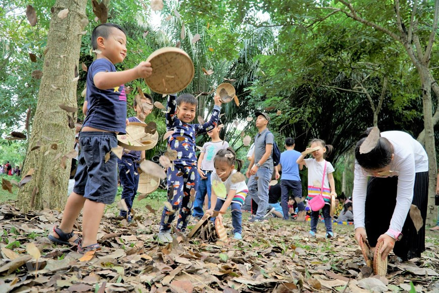 Des enfants jouent le jeu intitulé "Tourbillon de feuilles d'or". Photo: Vietnam+