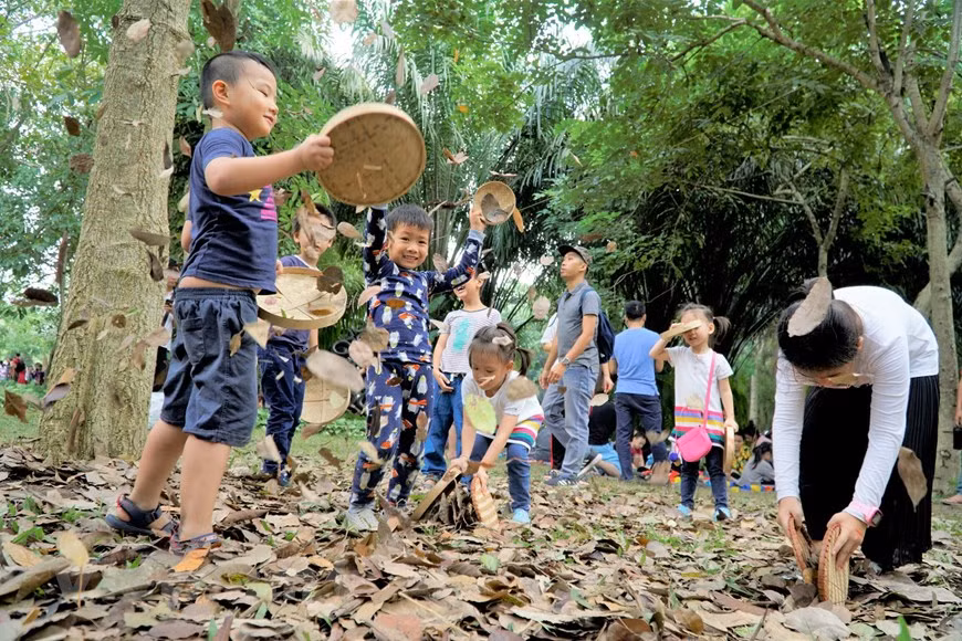 Des enfants jouent le jeu intitulé "Tourbillon de feuilles d'or". Photo: Vietnam+