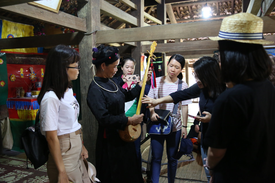 Les visiteurs découvrent le «dan tinh». Photo: VNA