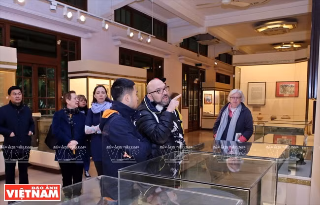  Des touristes reçoivent des informations complémentaires sur l’histoire du Vietnam après un ''City walk''. 