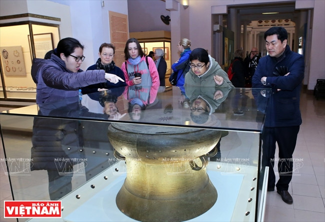  Des touristes découvrent les dynasties du Vietnam en regardant des objets exposés au Musée de l’Histoire du Vietnam.