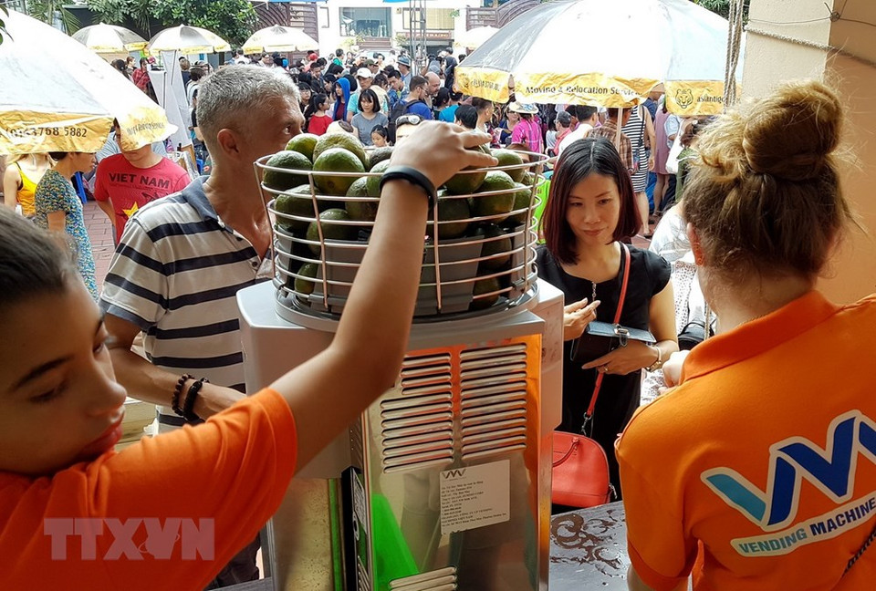  La machine à jus d'orange fonctionne à pleine capacité pour servir des clients.