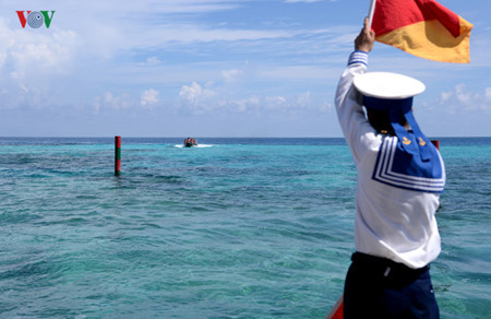 Un soldat guide le bateau pour qu’il puisse accoster l’île plus facilement.