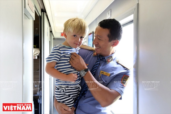 Vo Duc Ky, chef du train transvietnamien SE3 et un petit passager. Photo: Tât Son