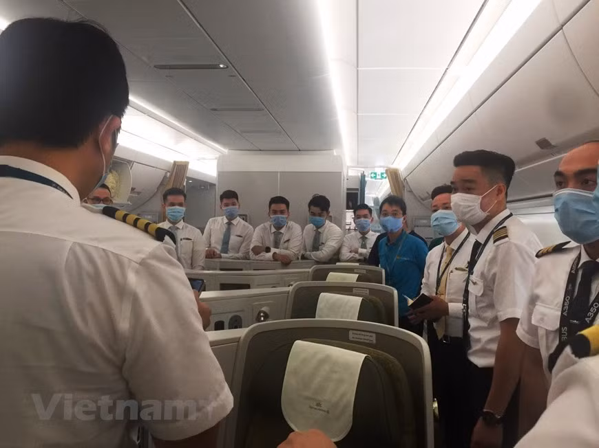 Une réunion pour préparer la procédure de rapatriement des travailleurs vietnamiens de Guinée équatoriale a été mise en oeuvre. Vietnam Airlines s'était préparé pendant un mois pour le vol spécial, avec des dizaines de réunions organisées pour discuter les détails de ce vol jamais effectué, sous la direction du Premier ministre, du Comité directeur national pour la prévention et le contrôle du COVID-19 et du ministère des Transports. Pour faire face à toutes les circonstances, le transporteur a décidé de choisir les membres d'équipage les plus expérimentés, le capitaine se rendant auparavant en Libye pour secourir les travailleurs vietnamiens. L'équipage de Vietnam Airlines sur le vol se compose de cinq pilotes, huit agents de bord et deux techniciens au sol. Photo: VietnamPlus