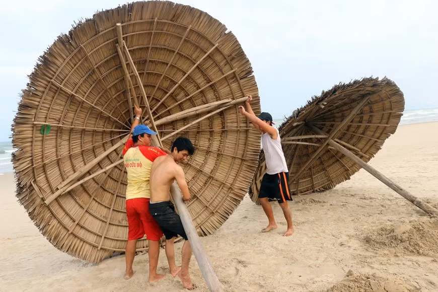 Des canapés et parasols sur la plage de My Khe sont enlevés pour éduire les dommages causés par le typhon (Photo: VNA)