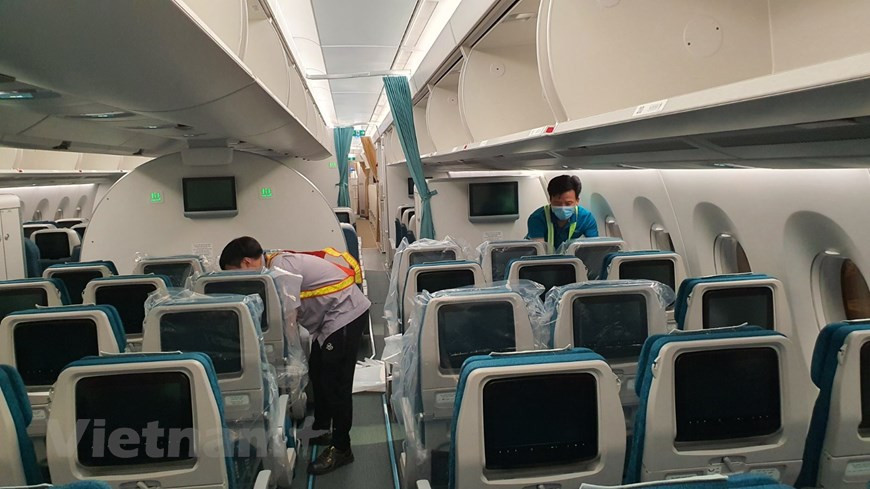 Tous les sièges de l'Airbus A350, qui transportent les membres d'équipage, le personnel médical et le matériel de santé de Hanoï à la ville de Bata, sont entièrement recouverts de plastique. Sur le dos, cinq lingettes humides alcoolisées, un sac poubelle et un guide pour les passagers sont insérés. Il s’agit du 41e vol de la compagnie aérienne nationale Vietnam Airlines pour rapatrier des citoyens vietnamiens à l’étranger vers le pays d’origine. Il s’agit d’un vol spécial avec pleins d’émotions. Ce vol a été décollé à un aéroport étranger avec pleins des conditions défavorables. Malgré des risques de contamination, tout le personnel de Vietnam Airlines est toujours prêt à œuvrer ensemble avec tout le pays à participer à la première ligne dans le combat contre le COVID-19. Photo: VietnamPlus