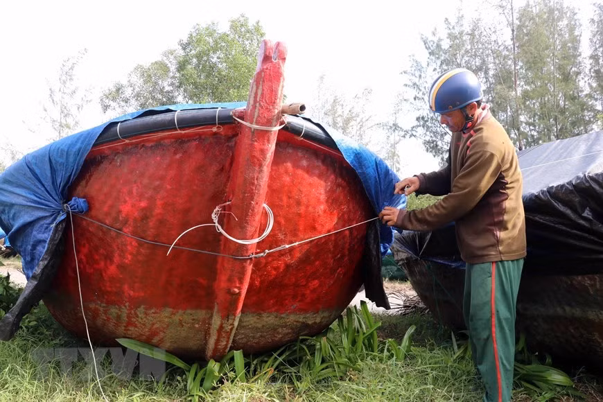 Des pêcheurs de la ville de Da Nang couvrent leurs bateaux pour éviter d'être touchés par la typon Molave 
