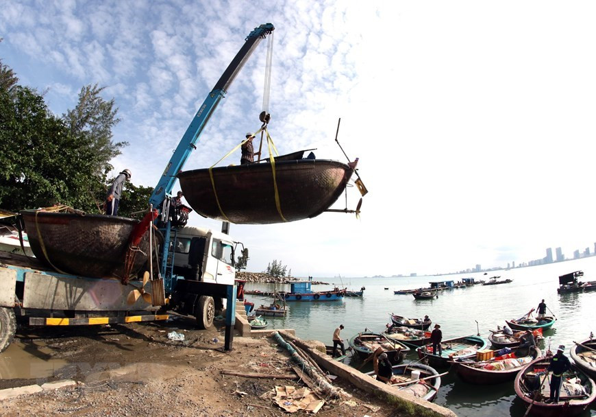 Des pêcheurs de Da Nang rassemblent leurs bateaux de pêche pour être amenés sur le continent à la tempête.