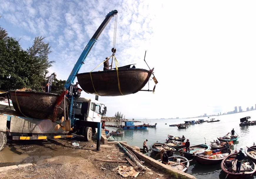 Des pêcheurs de Da Nang rassemblent leurs bateaux de pêche pour être amenés sur le continent à la tempête.