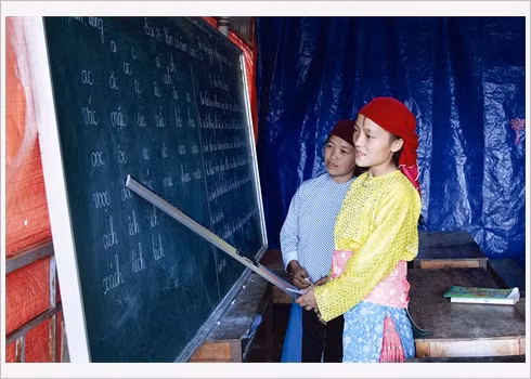 Giàng Thi May (droite) apprend le vietnamien à sa sœur, 29 ans, commence à apprendre à écrire.