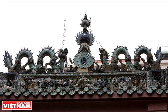 Des sculptures de deux dragons se battant pour une perle au dessus du portique de la pagode.