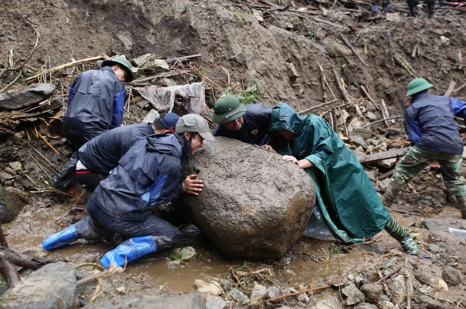 Les sauveteurs tentent de déplacer une grande pierre bloquant le passage.