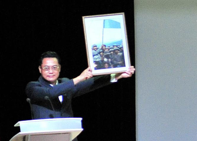 L’ambassadeur du Vietnam à Cuba, Nguyen Trung Thanh présente la photo prise le leader Fidel Castro hissant le drapeau traditionnel de l'unité Khe Sanh de l'Armée de libération Tri Thien-Hue.