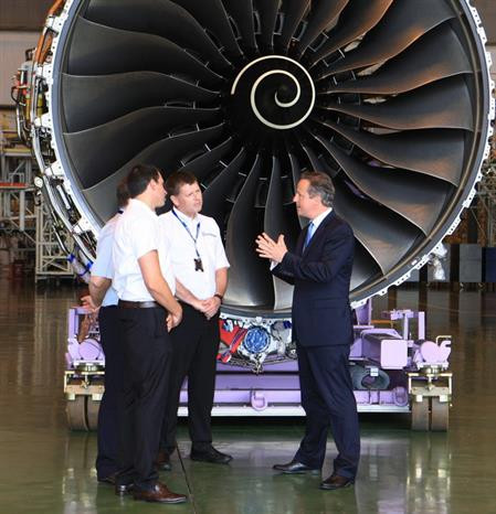Le Premier ministre britannique David Cameron (droite) échange avec trois experts à l’atelier de la sarl des techniques aériennes VAECO où s'effectue la maintenance des moteurs Rolls-Royce de la flotte d'A350 le 29 juillet 2015 à Hanoi.